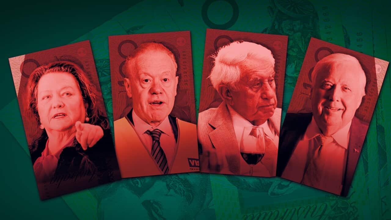 A woman wearing a pink blouse and a black suit is standing in front of a red background.