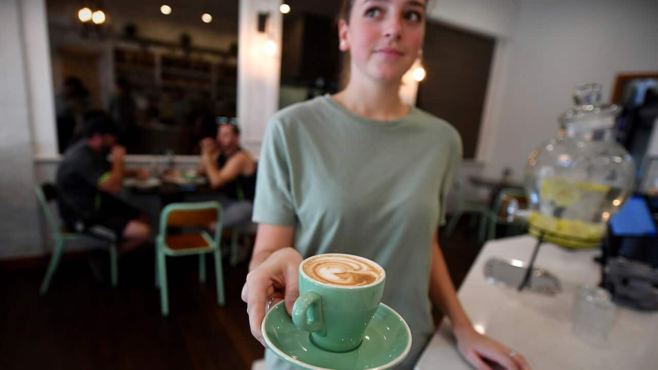 A waitress is seen holding a coffee at a cafe in Canberra, Thursday, Feb. 23, 2017.