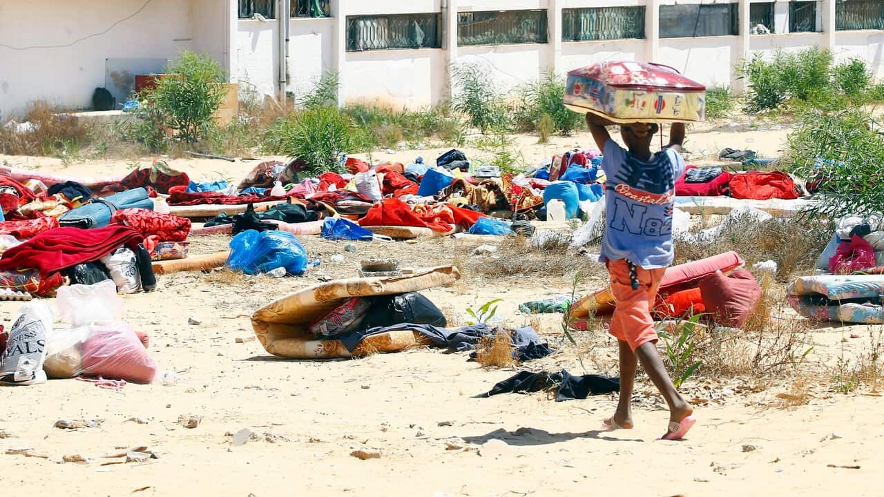 Migrants collects his belongings from the destroyed detention centre located east of Tripoli.