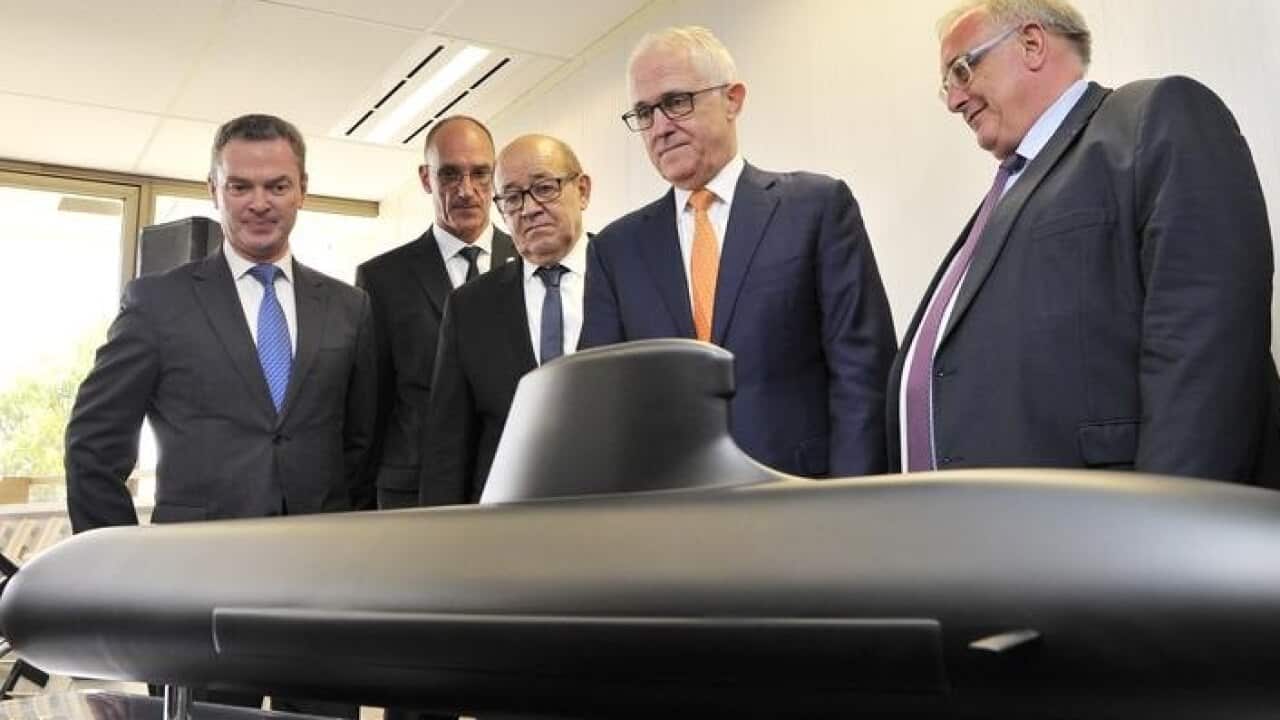 Malcolm Turnbull (C) looks at a model of a French-designed submarine