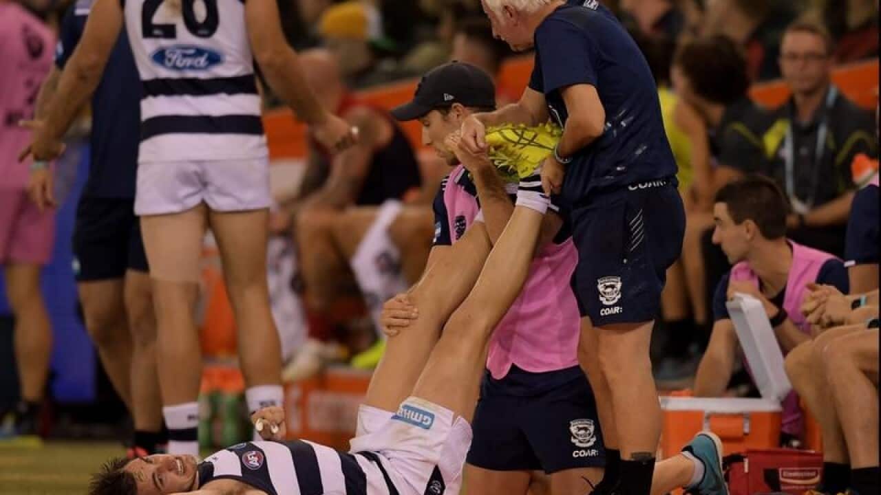 Daniel Menzel of the Cats has his legs worked on, on the boundary.