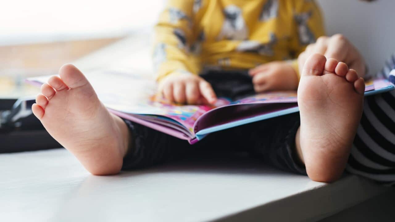 Cropped image of father and daughter with picture book at home
