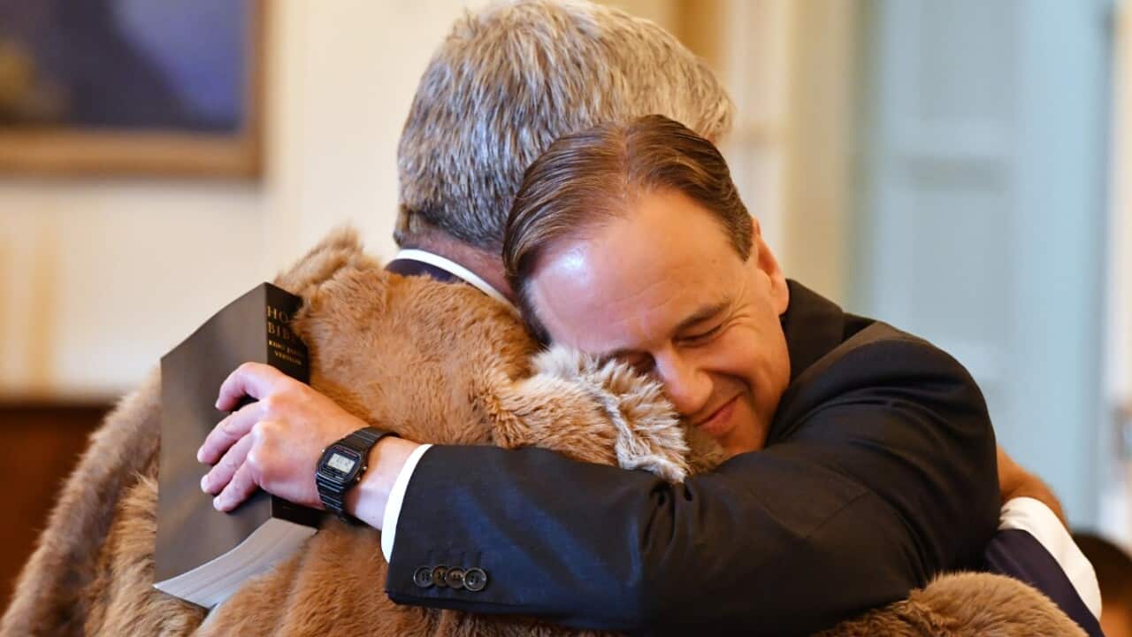 Minister for Industry Greg Hunt (R) hugs Minister for Indigenous Health and Aged Care Ken Wyatt at a swearing-in ceremony at Government House in Canberra