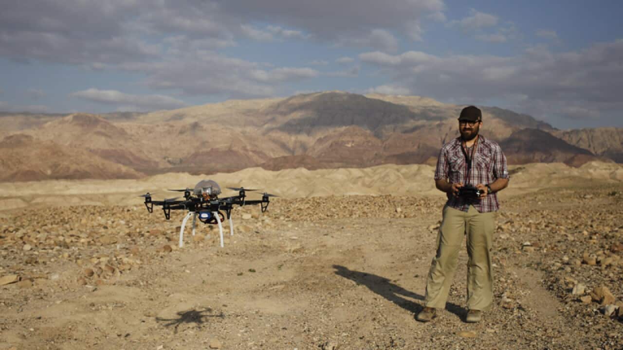 An archaeologist operates a drone at a cemetery in southern Jordan