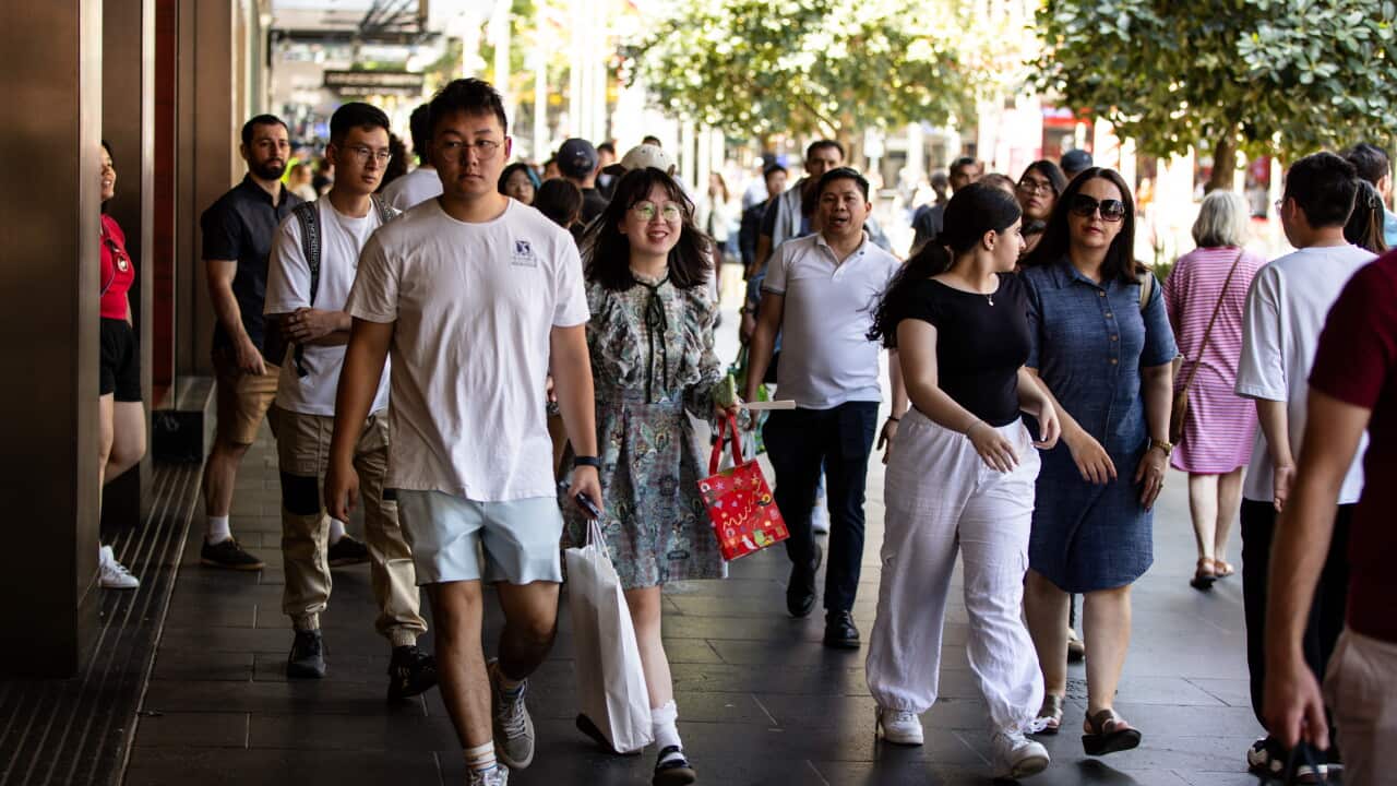 People walking around outside a shopping centre.