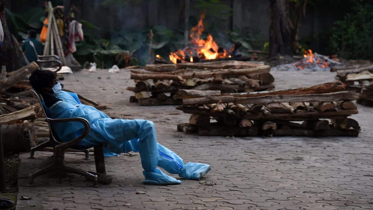 A municipality worker is shown exhausted during the last rites of people who died of the COVID-19 at a crematorium in Guwahati, India on 2 May.