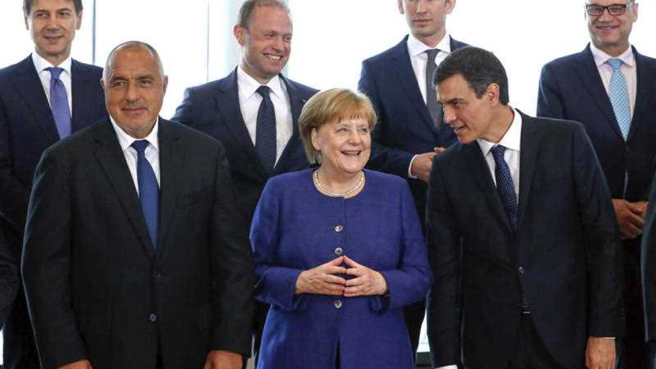 German Chancellor Angela Merkel, center, speaks with Spanish Prime Minister Pedro Sanchez, right, as they pose for a group photo at an informal EU summit on migration at EU headquarters in Brussels, Sunday, June 24, 2018.