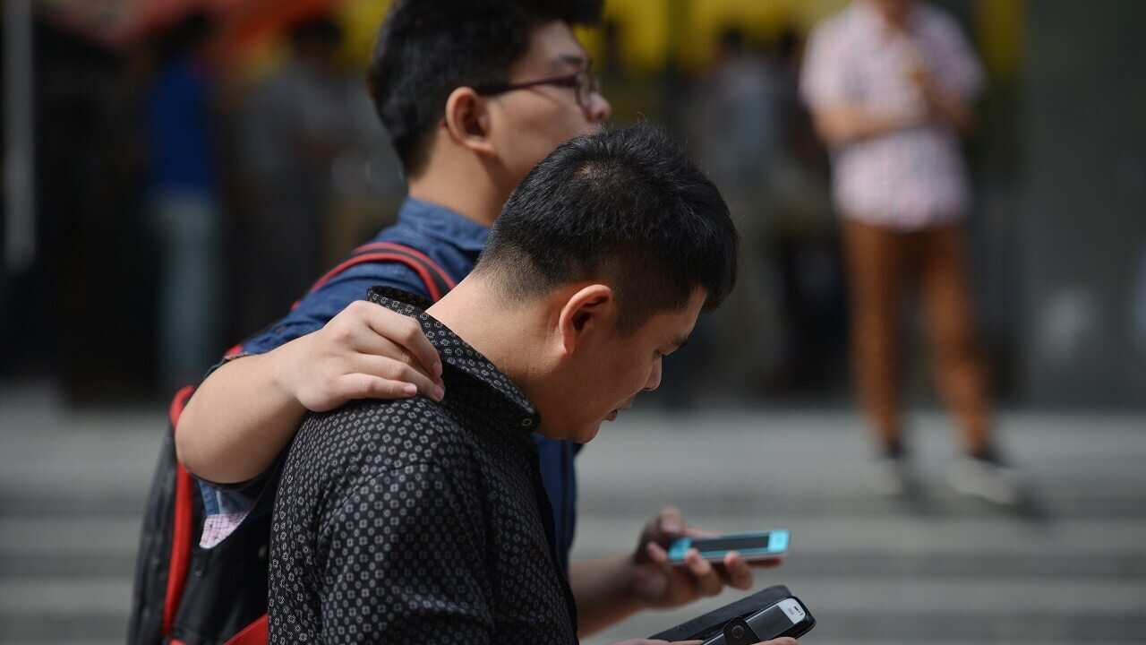 People use their mobile devices on the street.