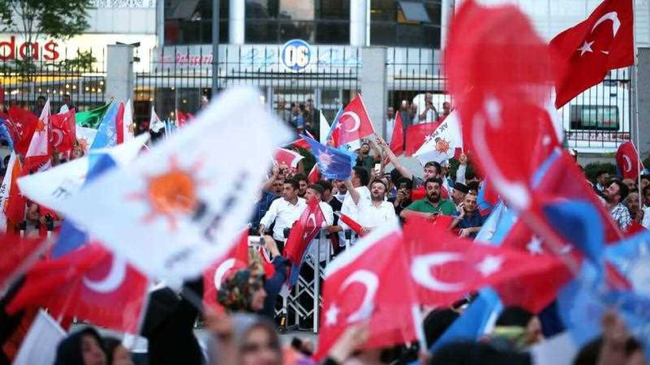Supporters of Turkish President Erdogan hold Turkish and AK Party flags and greet after closing voting for the Turkish presidential and parliamentary elections in Ankara, Turkey, 24 June 2018.