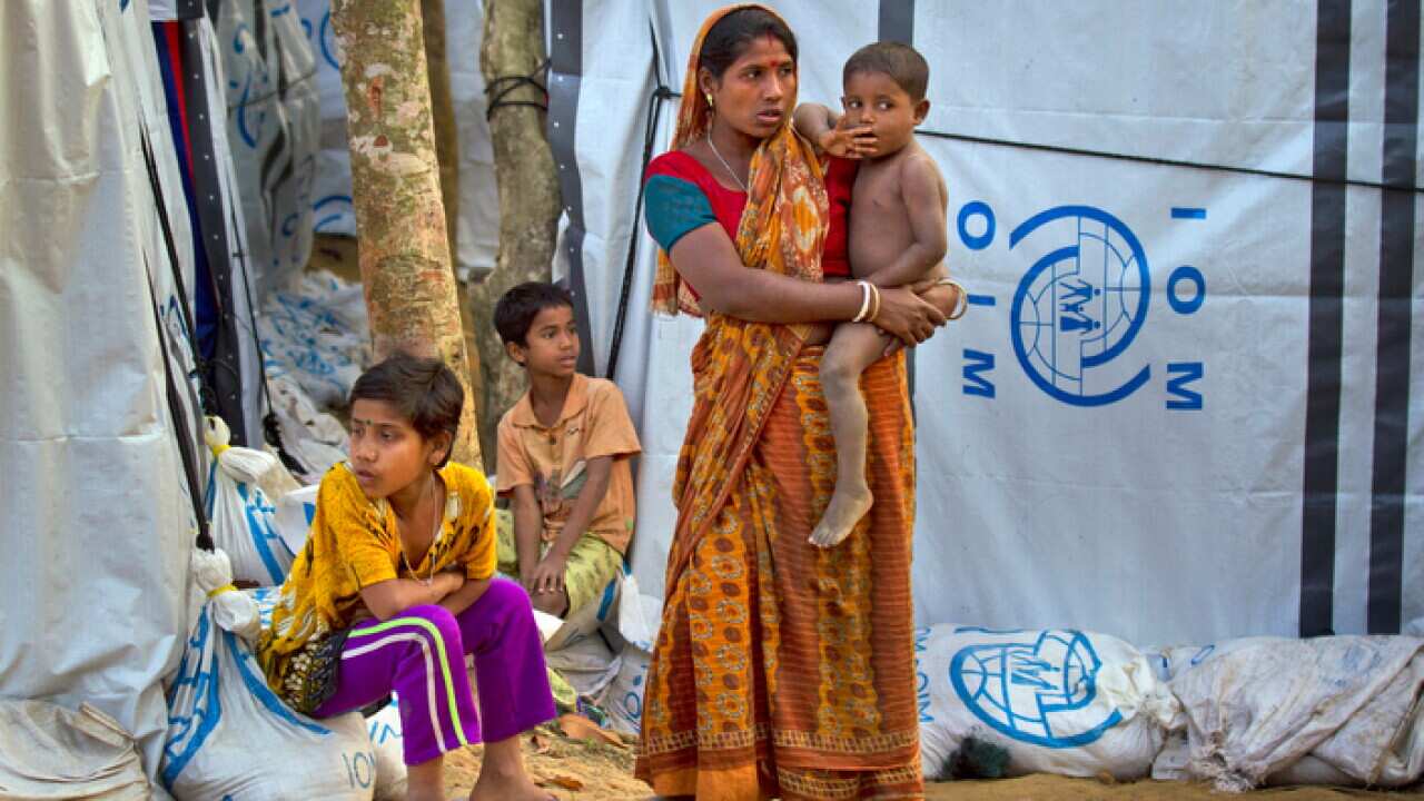 A Rohingya Hindu refugees woman with her child stands outside her make shift shelter near Kutupalong refugee camp near Cox's bazar, Bangladesh.