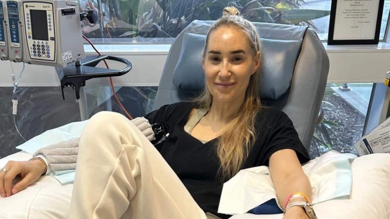 a woman with long blonde hair in hospital receiving chemotherapy