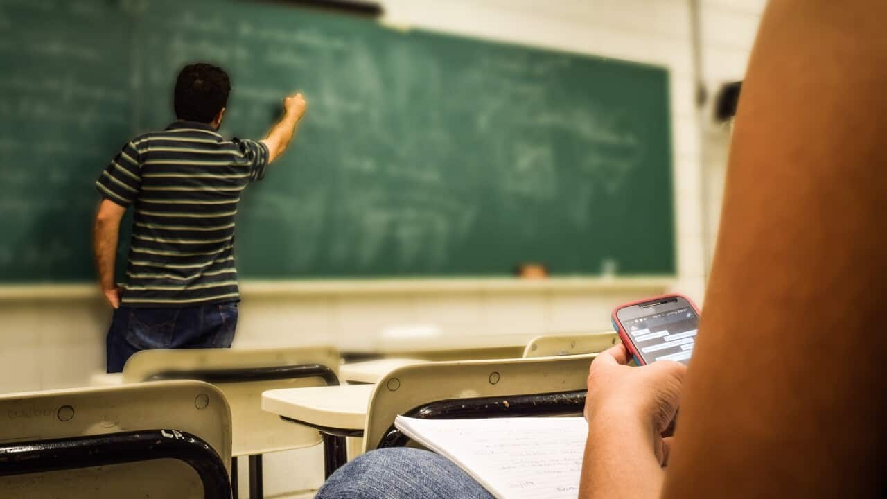 Student using mobile phone in classroom