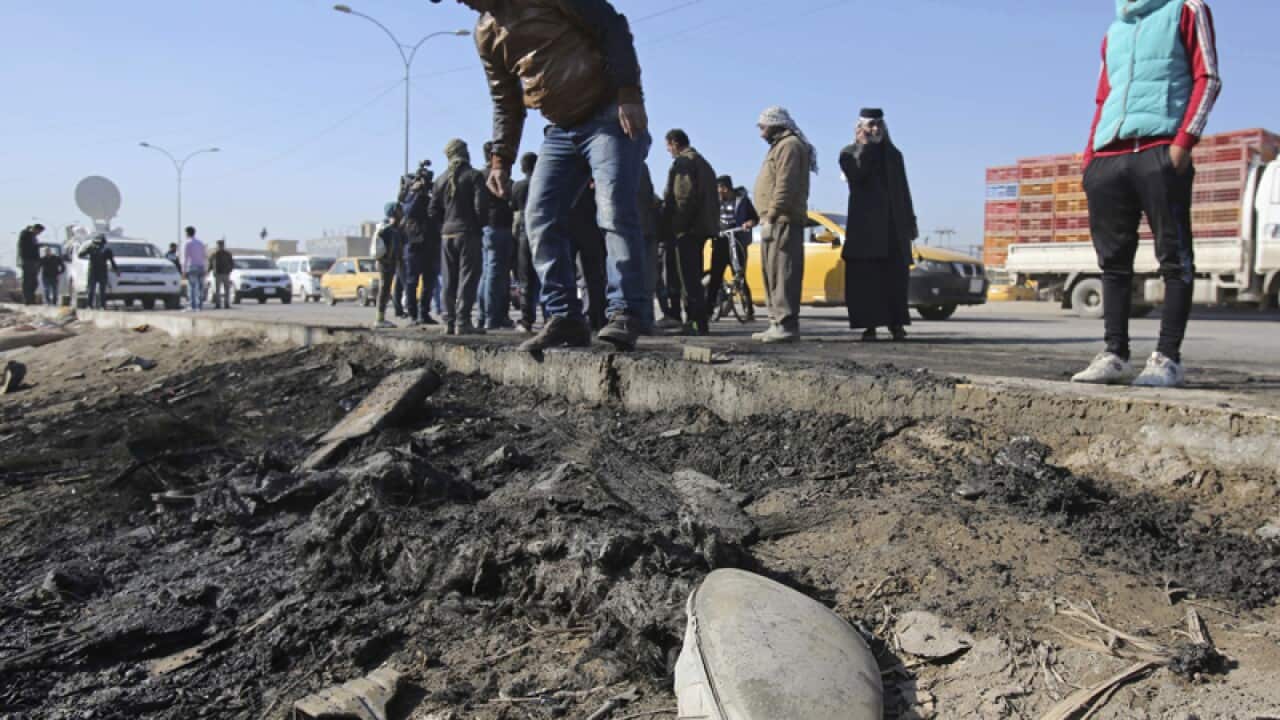 People gather at the scene of a car bombing