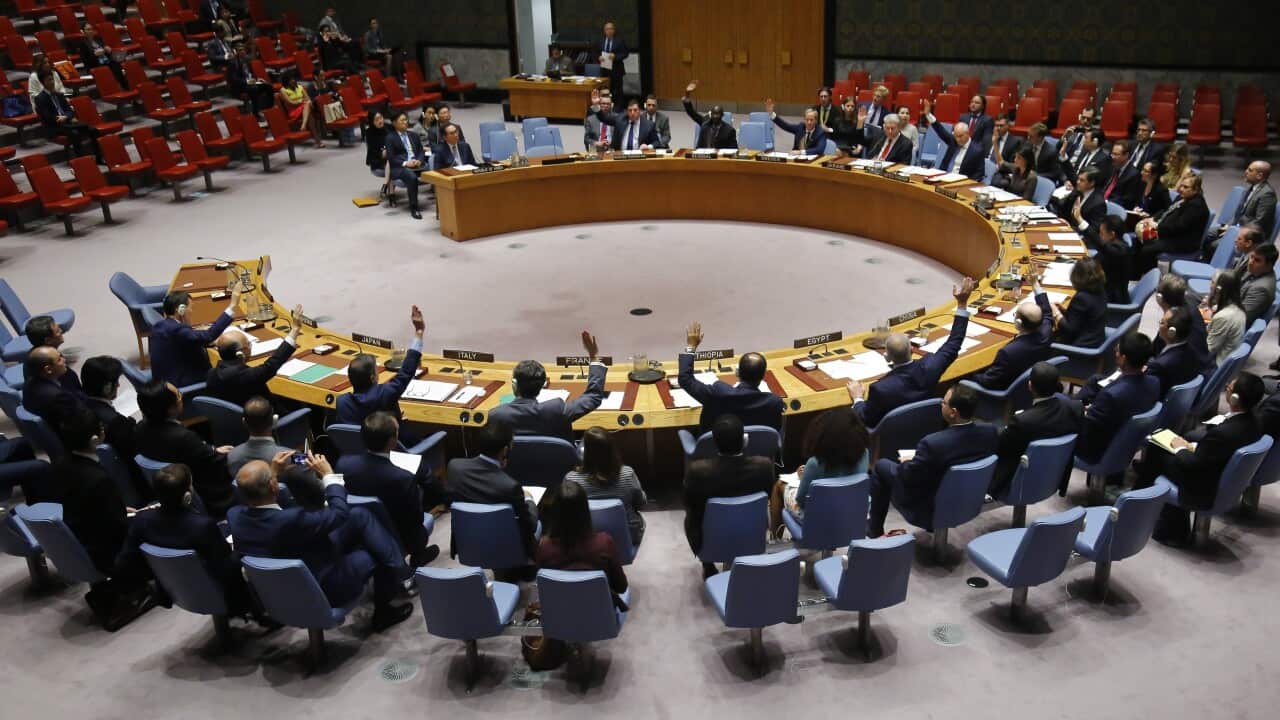 Ambassadors to the United Nations raise hands in a UN Security Council resolution vote to sanction North Korea.