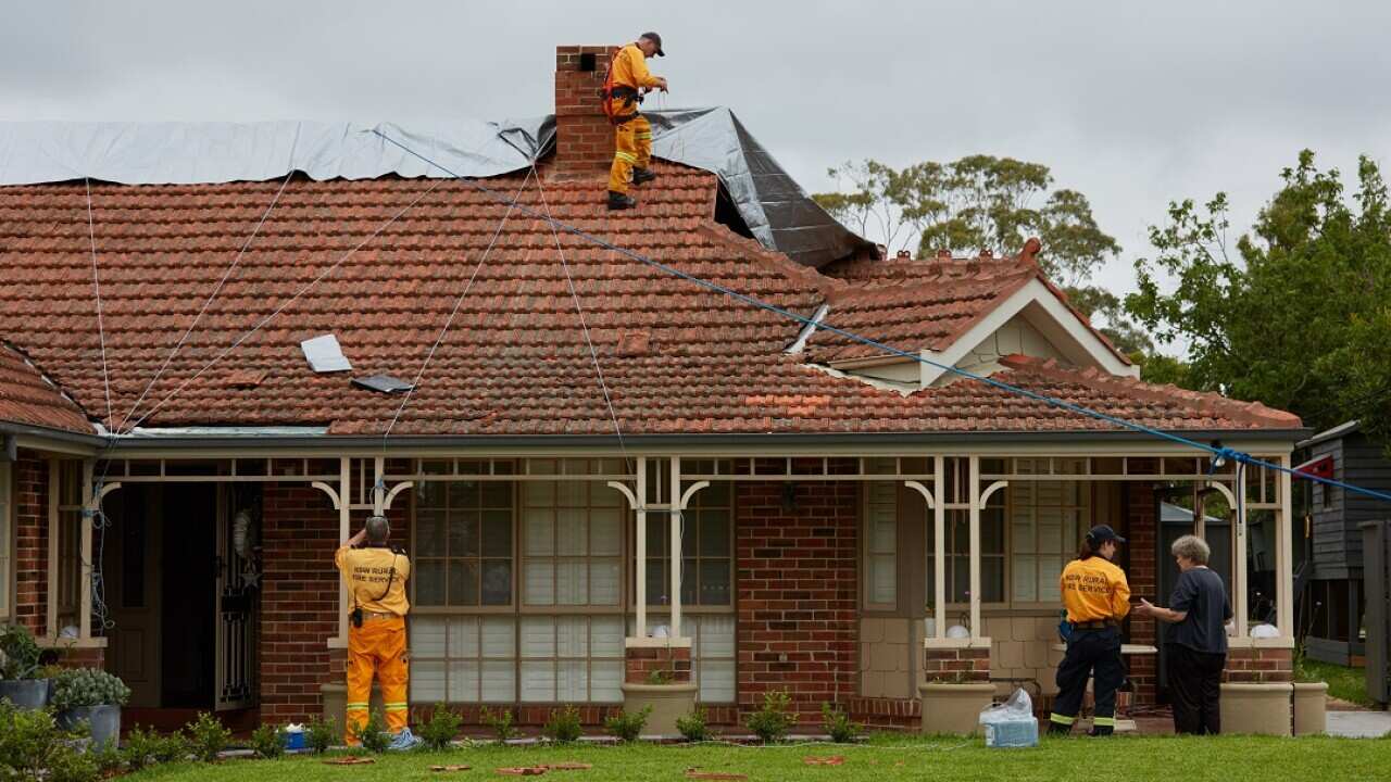 NSW Rural Fire Service workers help repair a house damaged in a hail storm overnight in Berowra Height.