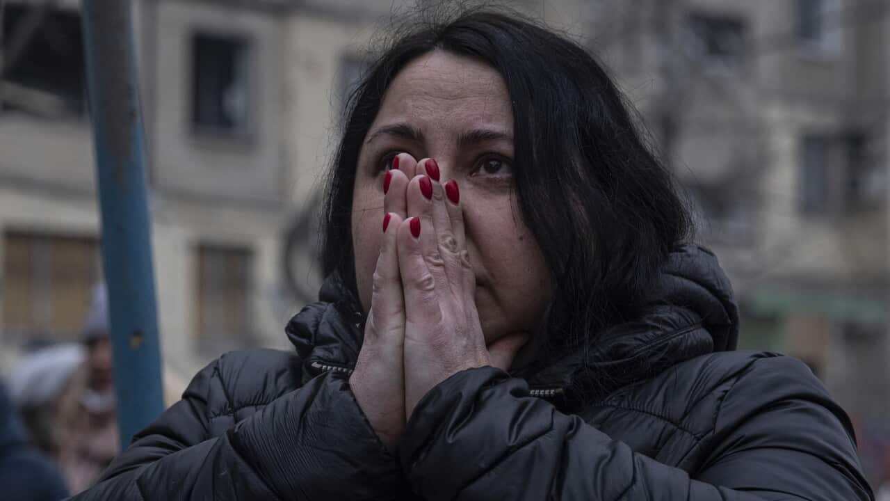 A woman with her hands in front of her face