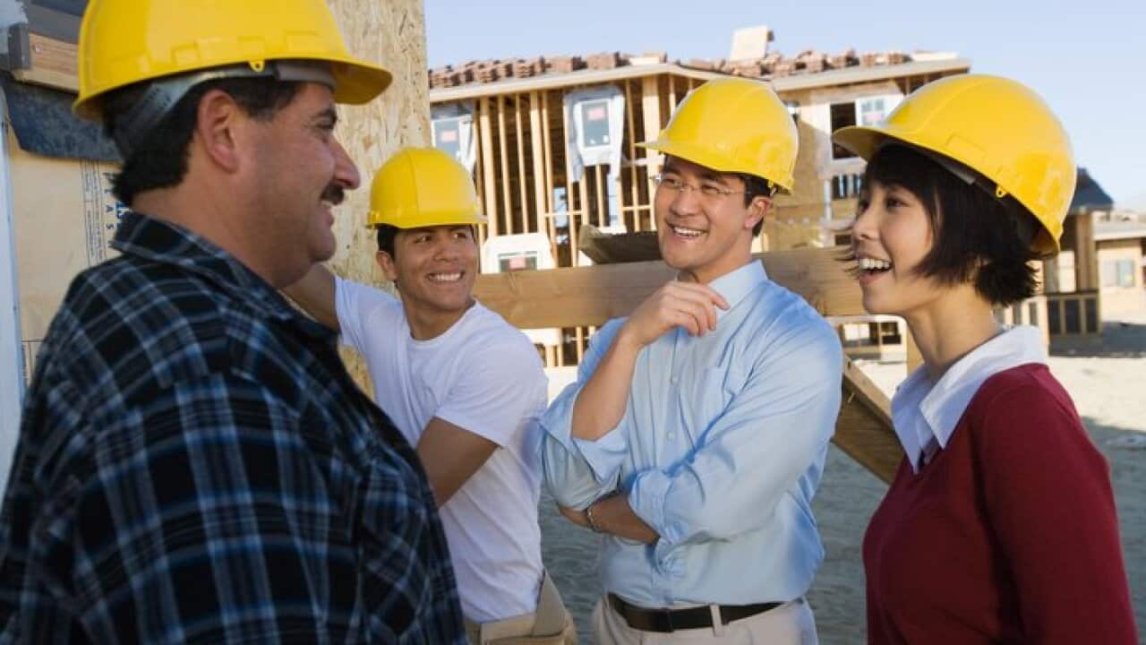 Smiling couple with construction workers