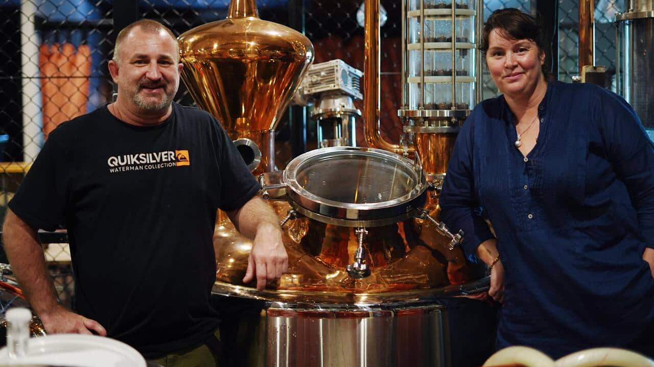 Bec Bullen and Heath Russell pose with distillery equipment