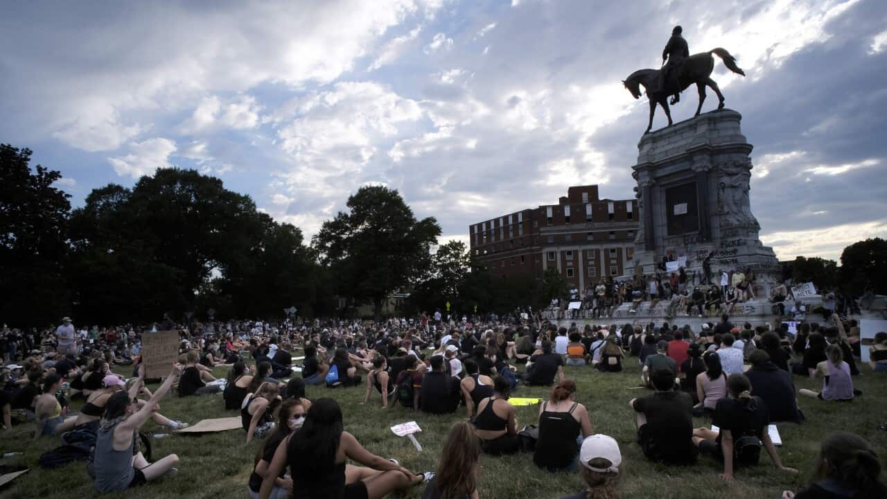 Protesters sit near the statue of Robert E. Lee on Monument Avenue in Richmond, Va., Wednesday, June 3, 2020. (Bob Brown/Richmond Times-Dispatch via AP)