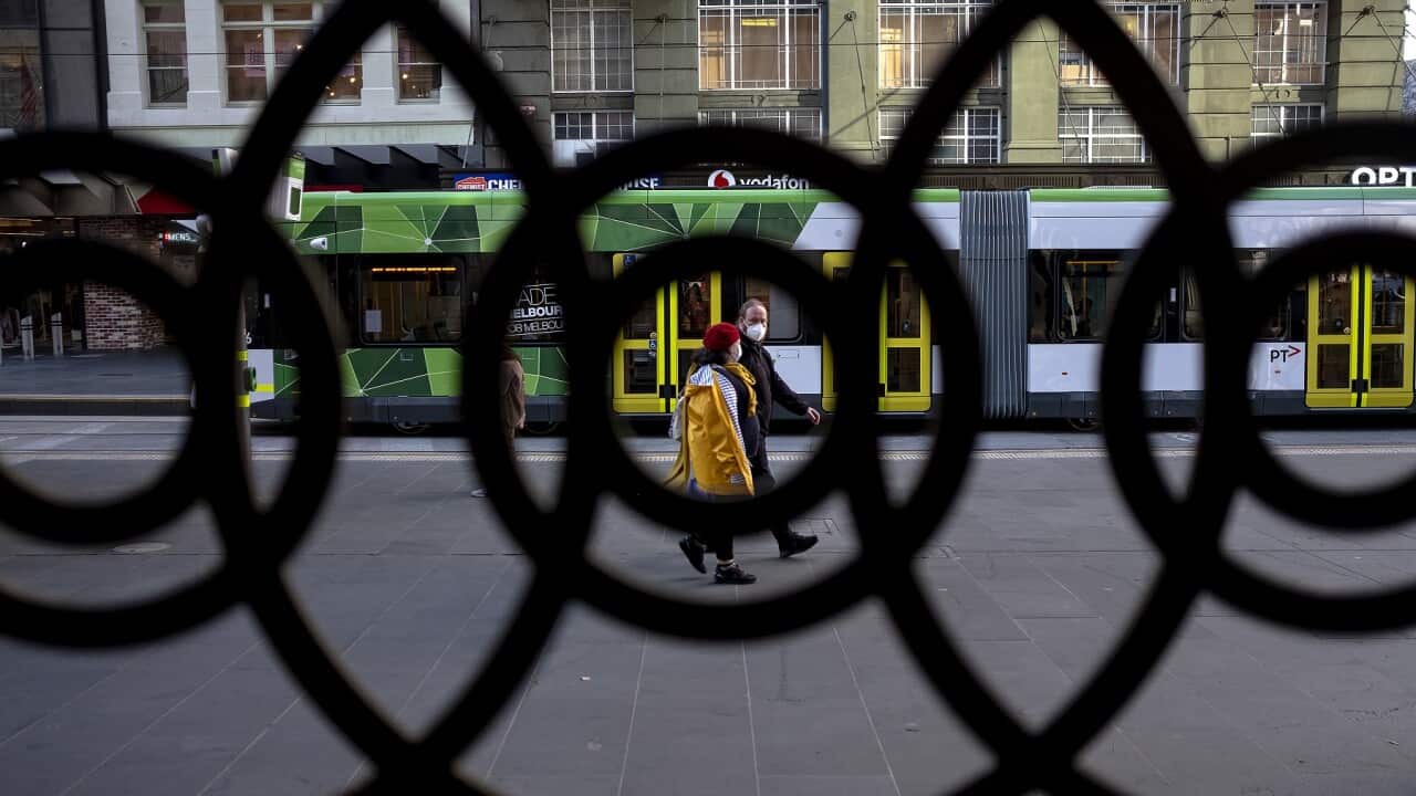 People wearing face masks are seen during a lockdown in Melbourne, Thursday, July 9, 2020. The Melbourne metropolitan area was put in locked down on Thursday in an effort to slow the spread of coronavirus. (AAP Image/Luis Ascui) NO ARCHIVING