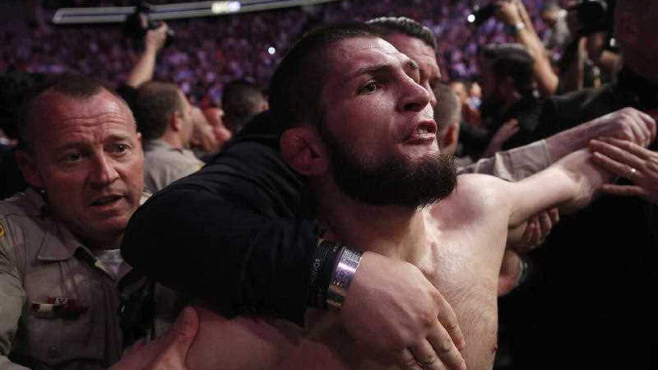 Khabib Nurmagomedov is held back outside of the cage after fighting Conor McGregor in a lightweight title mixed martial arts bout at UFC 229 in Las Vegas, Saturday, Oct. 6, 2018.