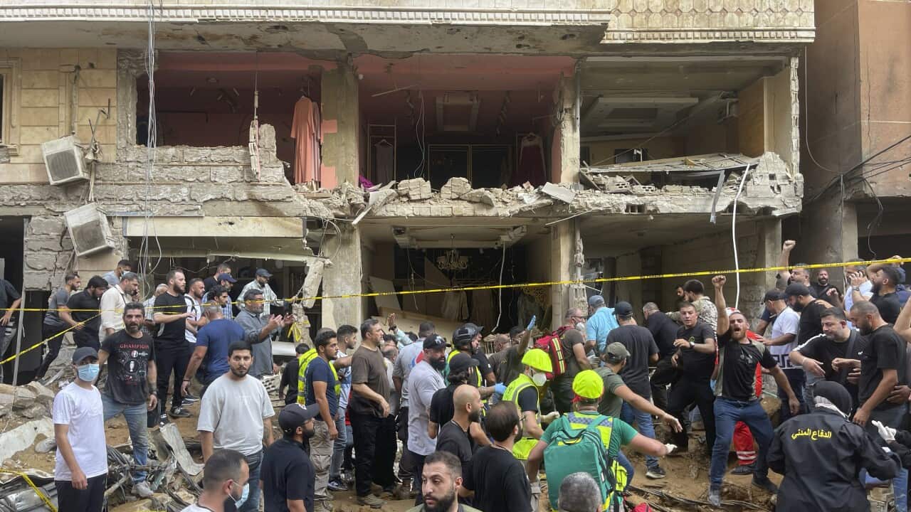 People gather near a damaged building.
