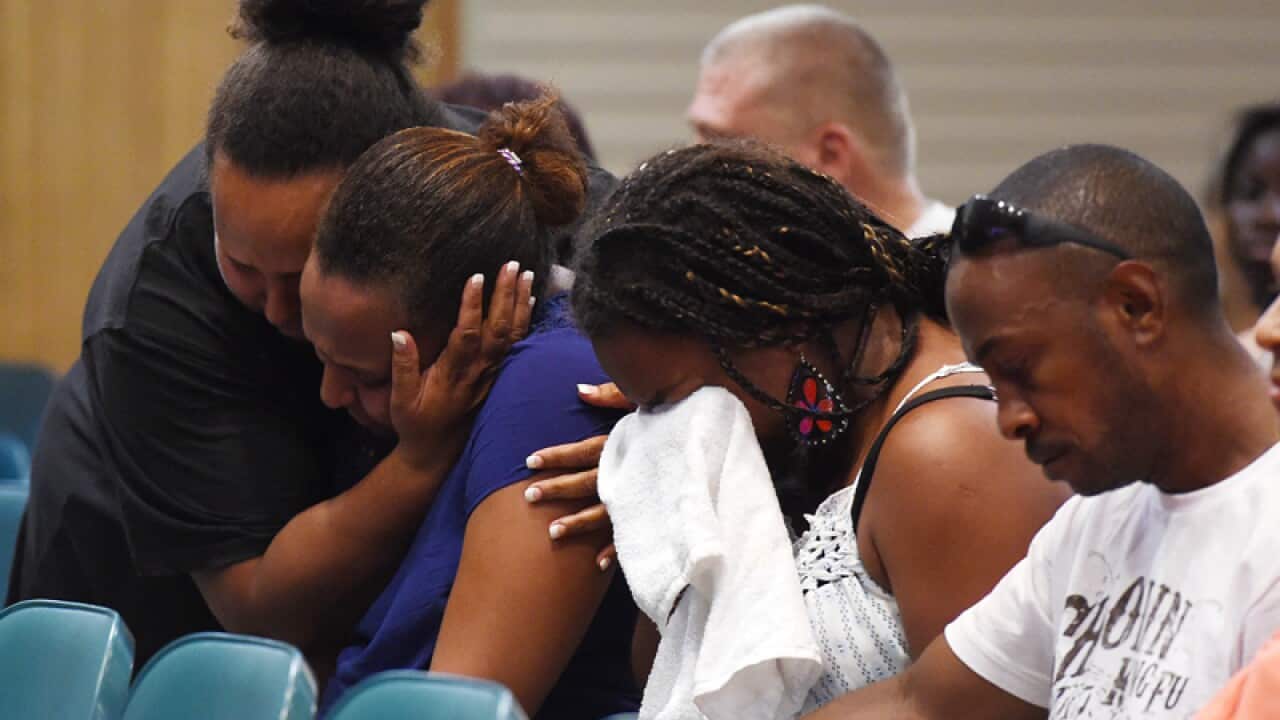Mourners at a memorial service for eight children