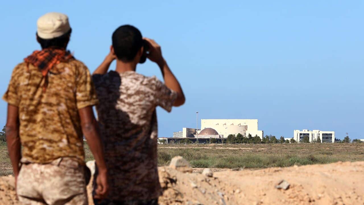 Fighters from the pro-government forces loyal to Libya's Government of National Unity (GNA) look through binoculars towards Sirte's conference centre,