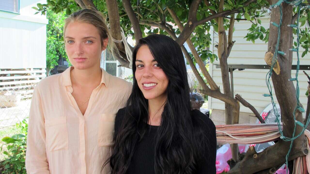 Courtney Wilson, left, and Taylor Guerrero posing for a photo in Honolulu. Honolulu will pay $80,000 to settle the lesbian couple's lawsuit. (AP)