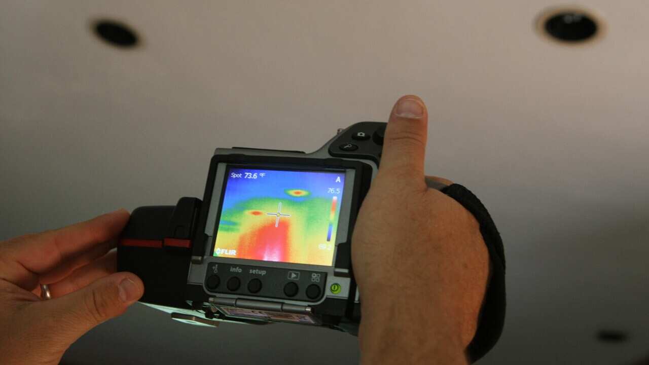 An infrared camera shows that hot air from the attic is coming through the light fixtures in the li