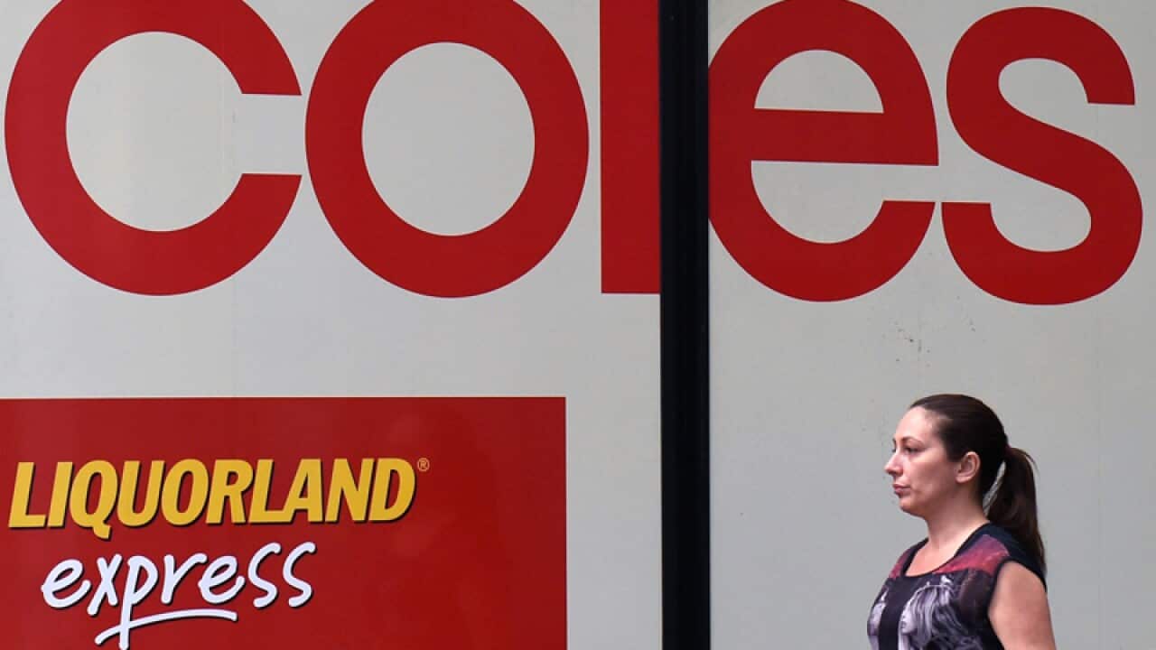 A pedestrian walks past Coles store in Sydney
