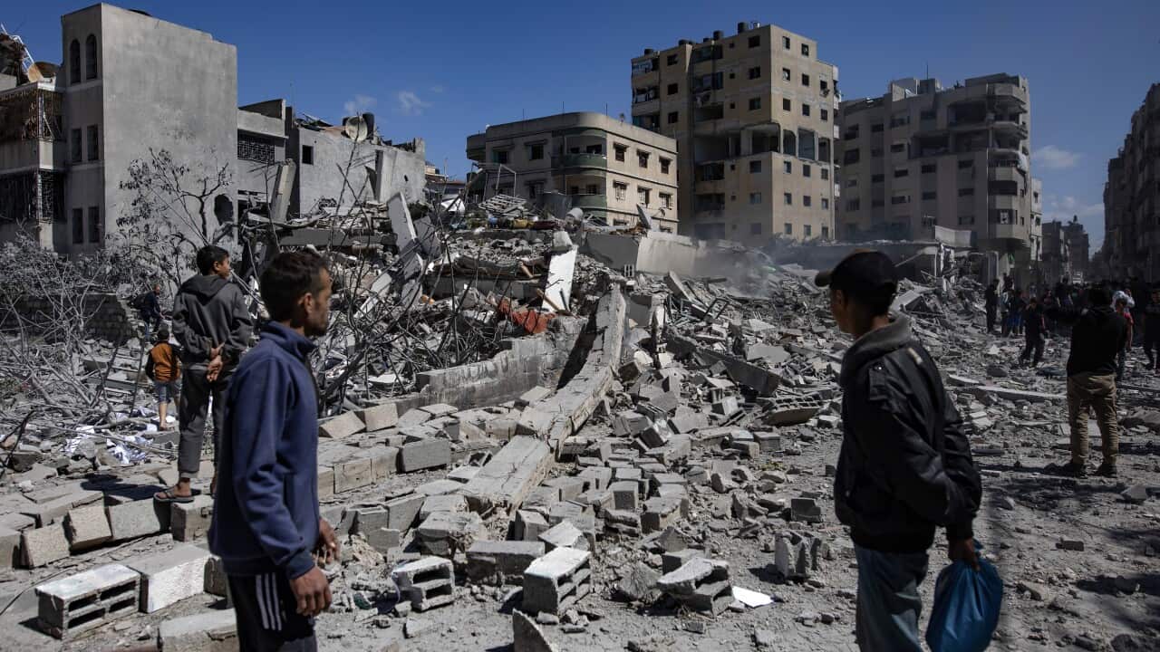 Several people inspect rubble after airstrikes on Gaza.
