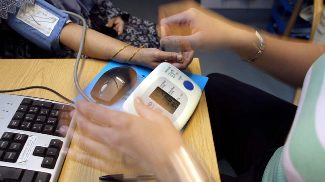 A GP takes a woman's blood pressure