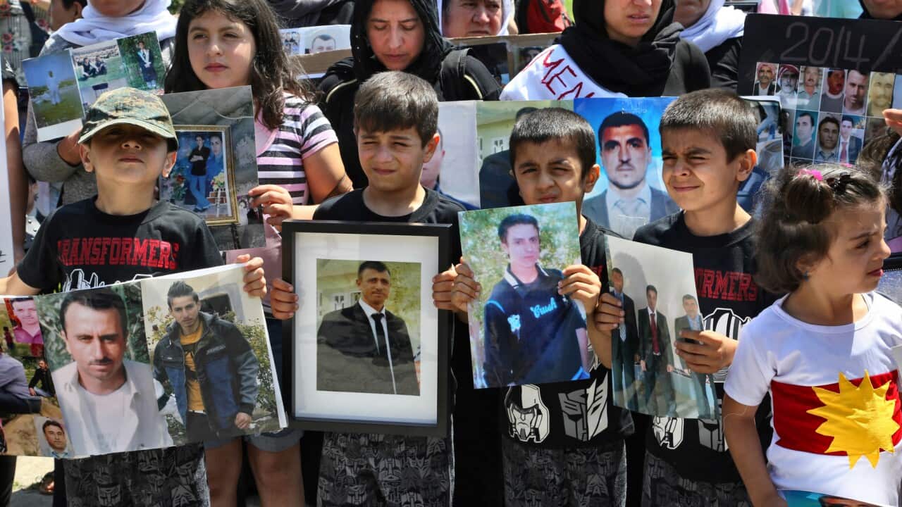 Yazidi children at a protest in Toronto, Canada, hold photos of family members killed by ISIS