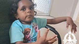 A girl wearing a blue shirt sits in a chair