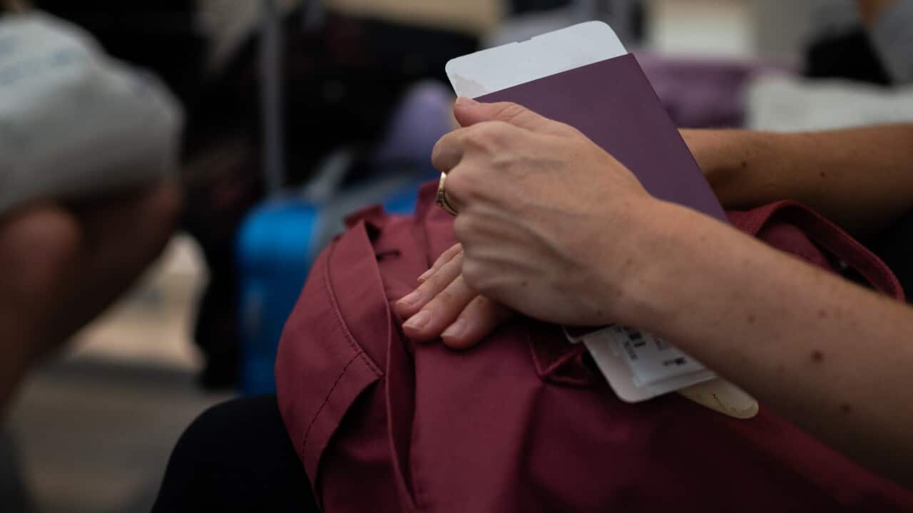 Person waiting, holding passport and boarding pass at the airport terminal