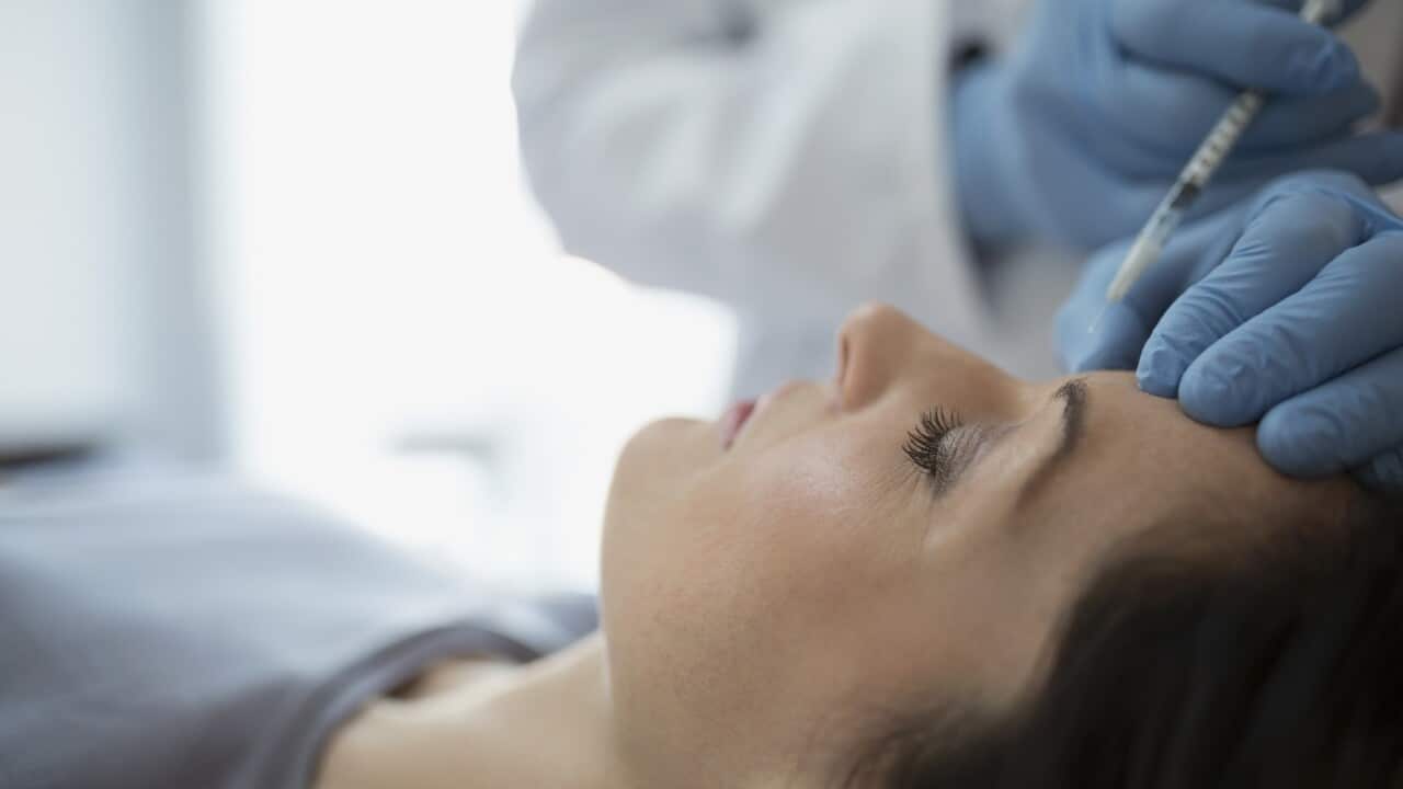 Woman receiving Botox injection in forehead