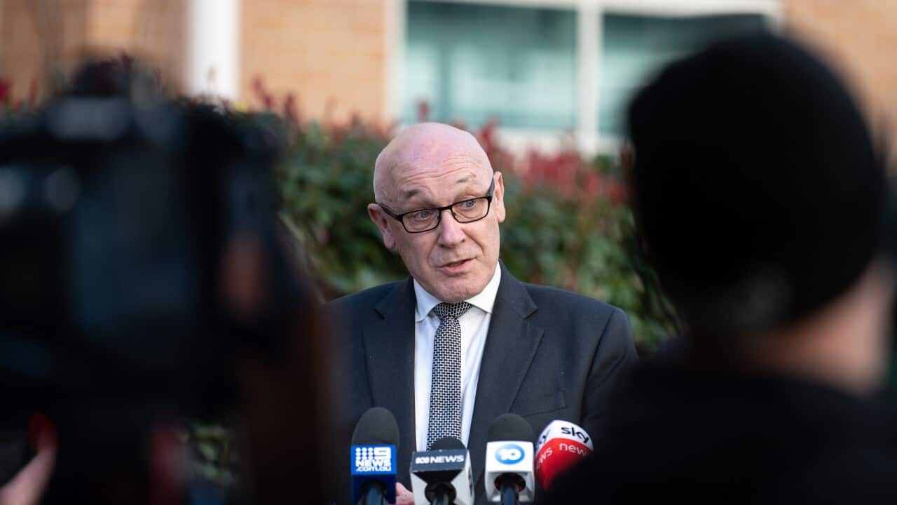 Damien Tudehope stands in front of microphones at a media conference.