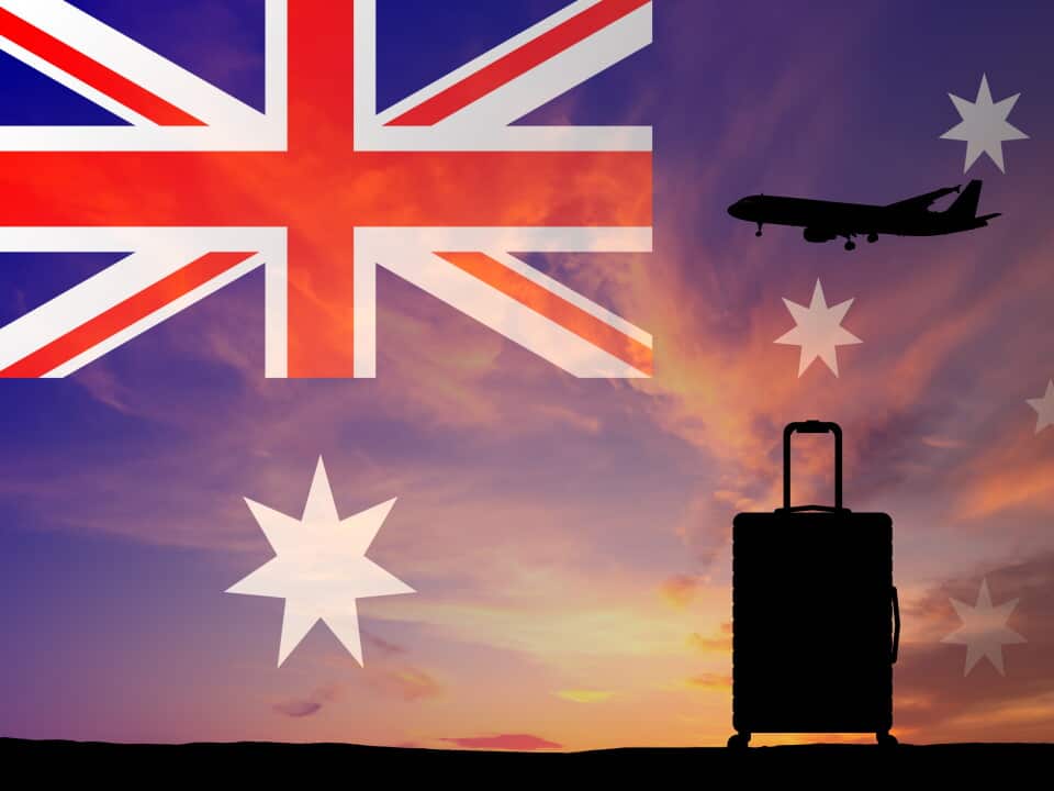 Suitcase and airplane against the background of the Australian flag