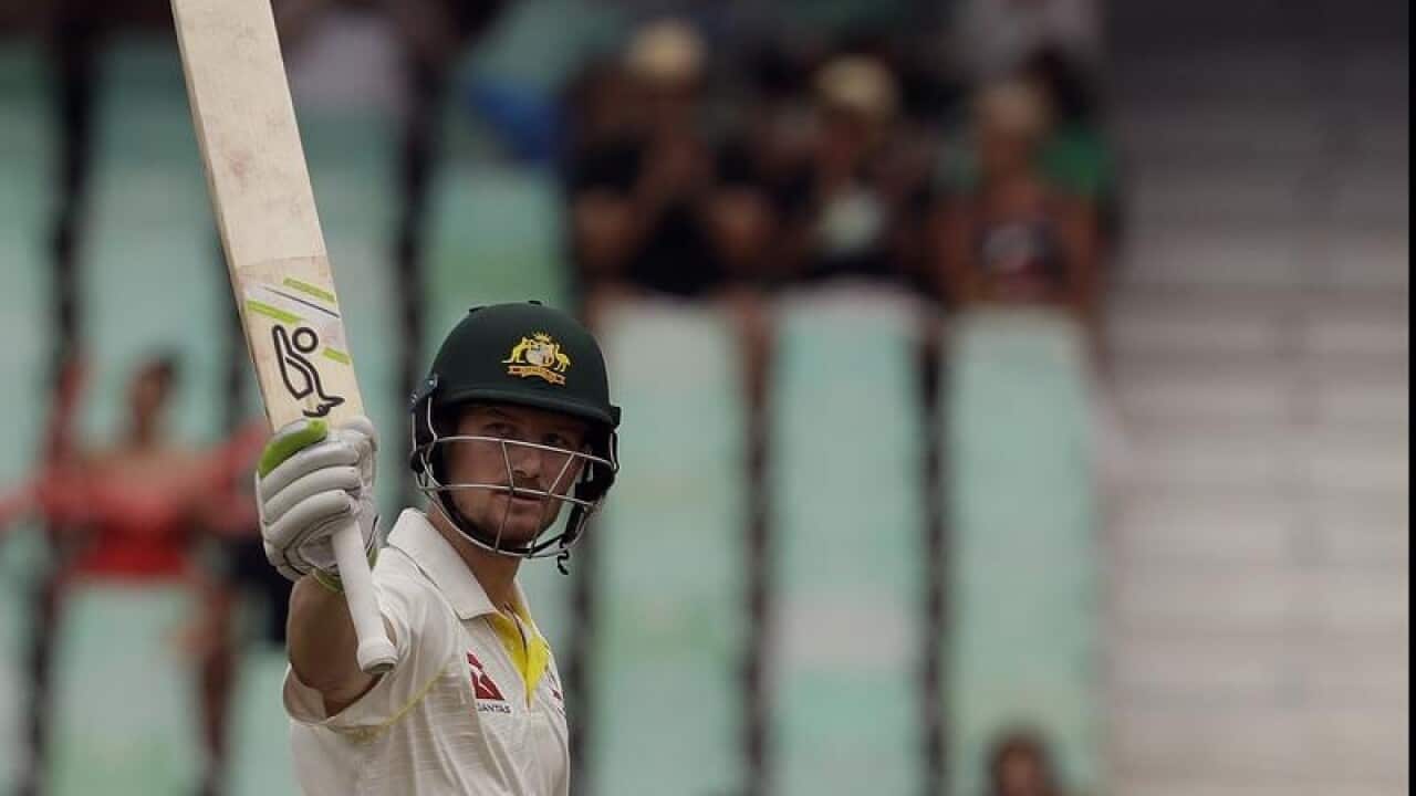 Australia's batsman Cameron Bancroft raises his bat after reaching 50.