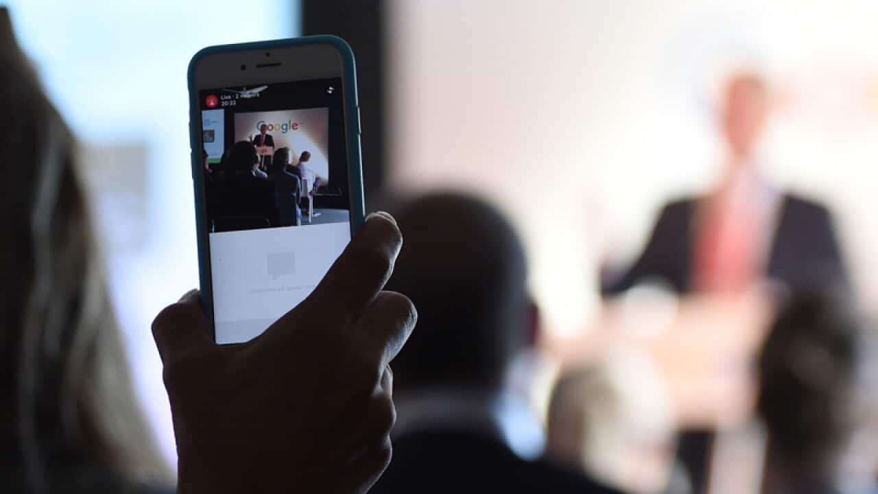 A person records a speech by Prime Minister Malcolm Turnbull