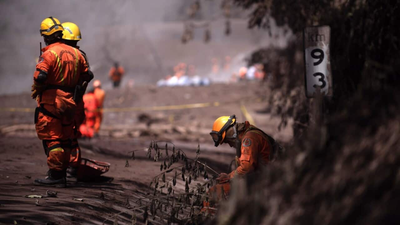 Rescuers take a break while the search and rescue efforts continue, in the area of El Rodeo, in the department of Escuintla, Guatemala