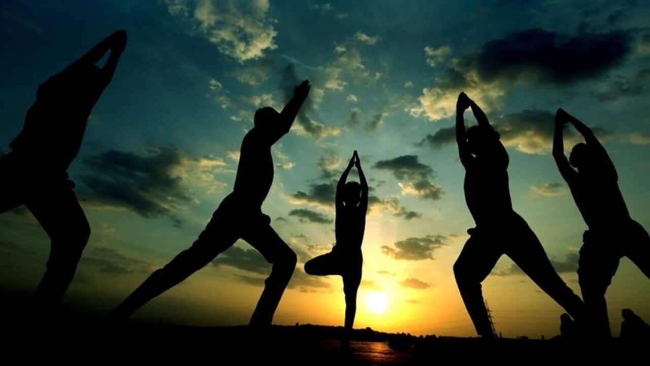 Indian children practice Yoga as the sun sets