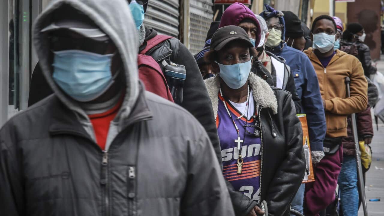 People wait for a distribution of masks and food in the Harlem neighborhood of New York.