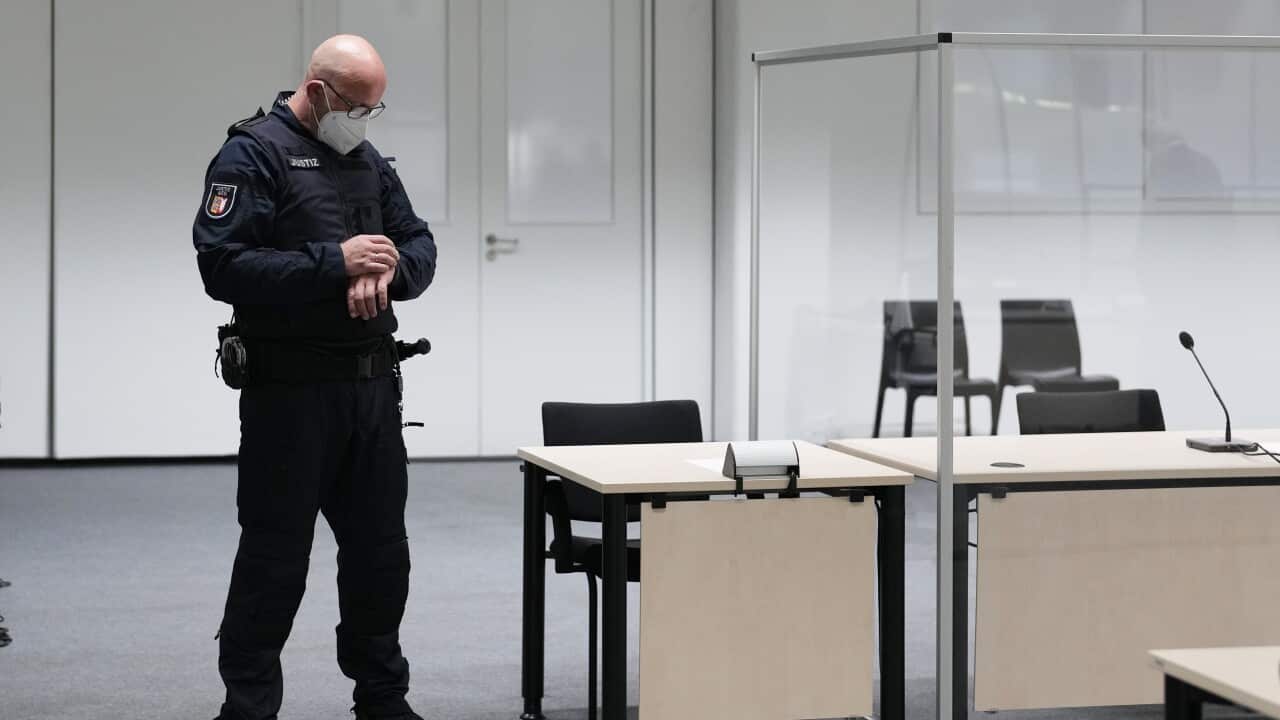 A court official looks at his watch in the courtroom before the trial of a 96-year-old former secretary to the SS commander of the Stutthof concentration camp.