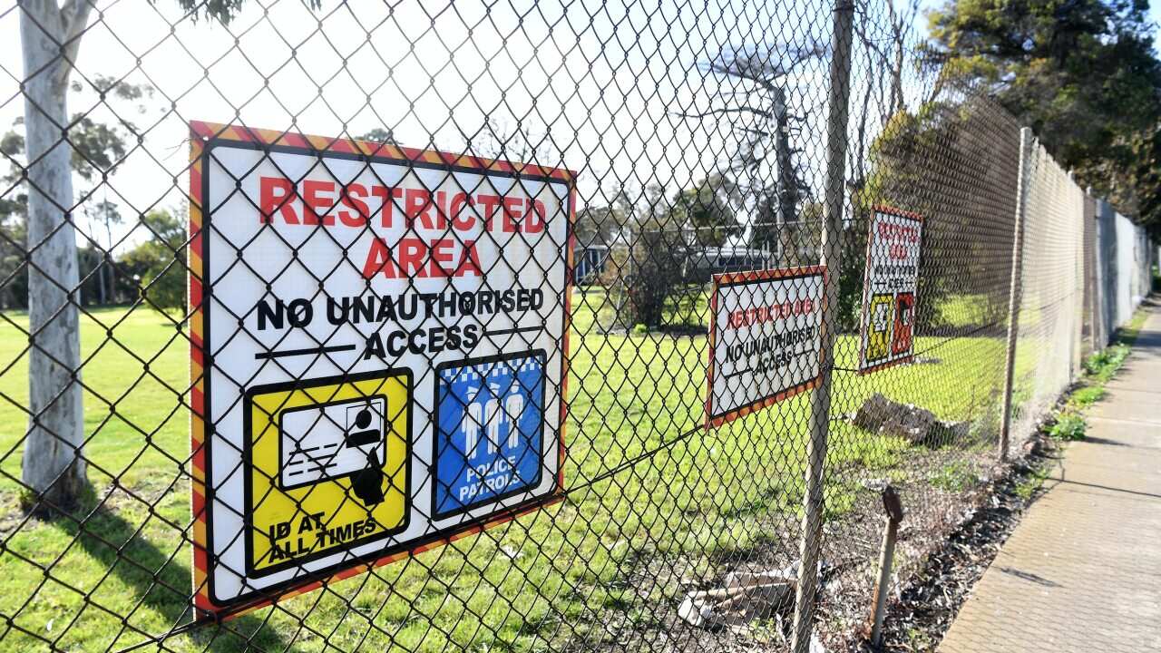 Signage is seen along the perimeter fence of the Melbourne Immigration Transit Accommodation complex in Broadmeadows, Melbourne.