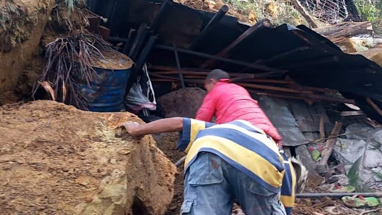 Locals look into a demolished house at the site of the landslide (Getty)