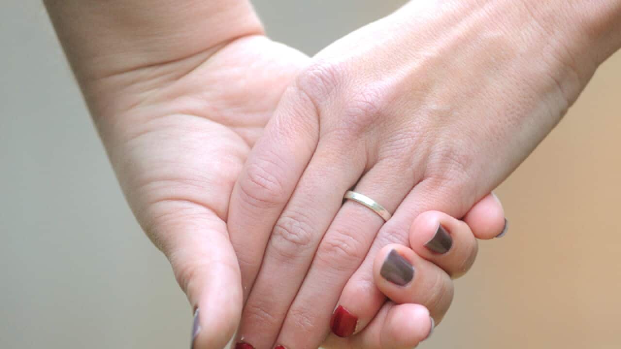 Women hold hands in Canberra