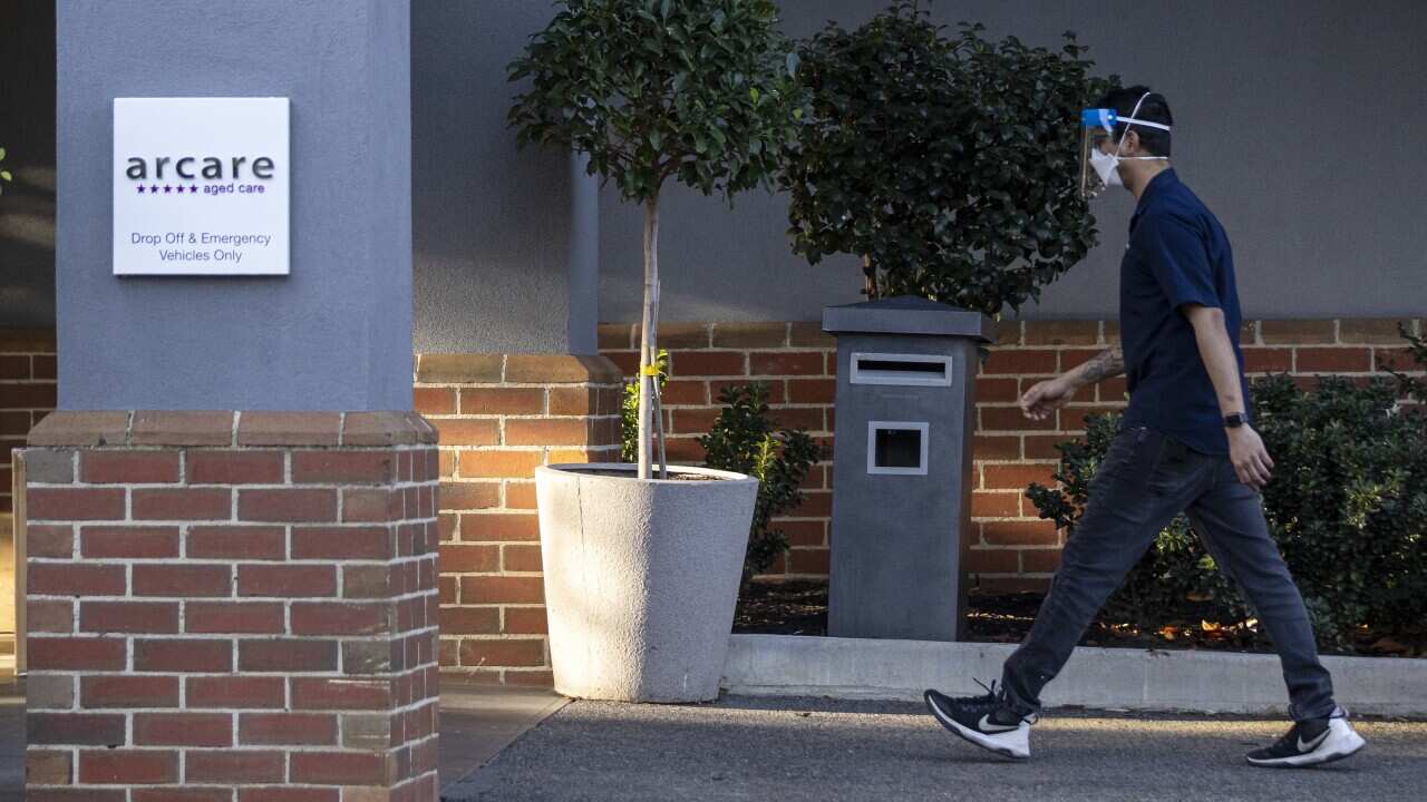 A staff member is seen entering Arcare aged care in Maidstone, Melbourne. The facility was locked down after two workers and a resident tested postive.