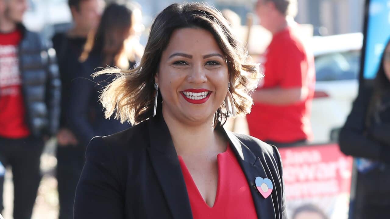 A woman is seen smiling while walking.
